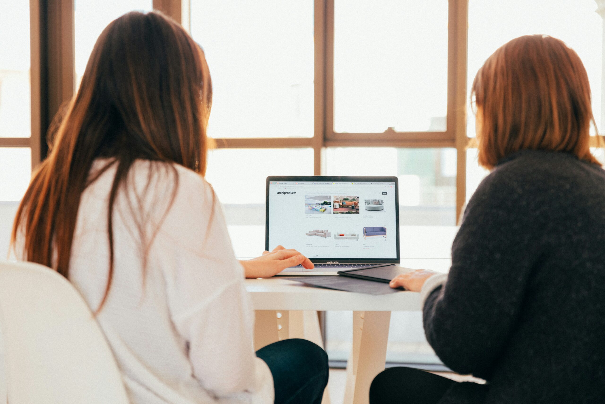 Two women working together on a computer