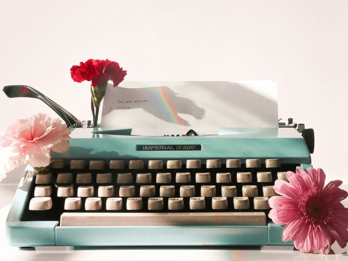 WordPress fundamentals, typewriter that reads, "You are enough. Always." With a rainbow and flowers.